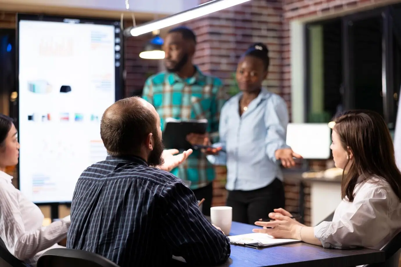 Kollegen prüfen Finanzberichte auf dem Bildschirm